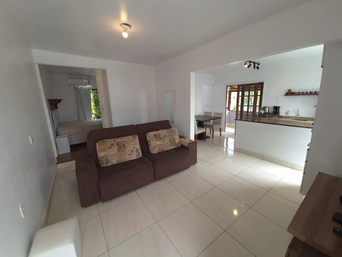 Sala de estar aconchegante da Casa de Cima com sofá e TV smart